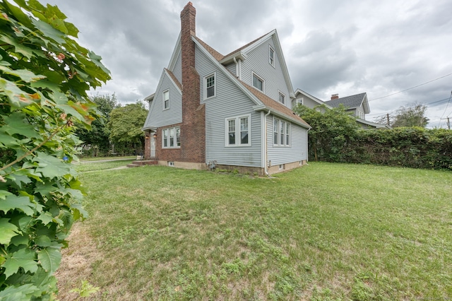 7 Ellsworth St, East Hartford, CT 06108 - view of home's exterior with a chimney and a yard