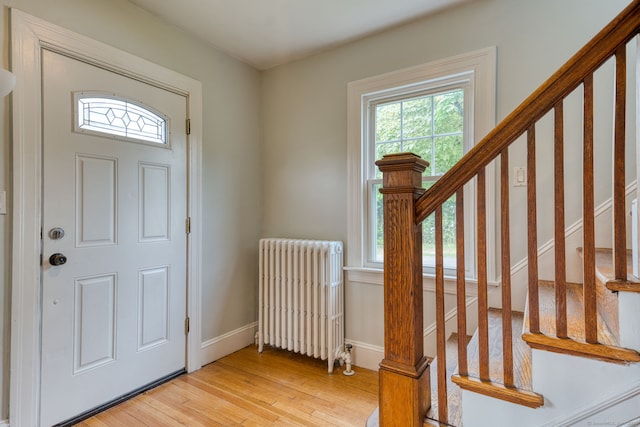 7 Ellsworth St, East Hartford, CT 06108 - entrance foyer with radiator heating unit, healthy amount of natural light, light wood-style floors, and stairway
