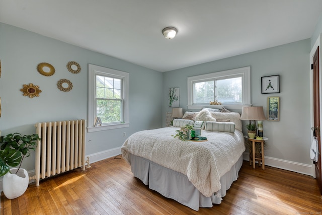 7 Ellsworth St, East Hartford, CT 06108 - bedroom with radiator heating unit, multiple windows, and hardwood / wood-style floors