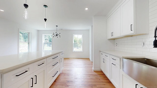 55A Moulthrop St, Ansonia, CT 06401 - kitchen with healthy amount of natural light, tasteful backsplash, light wood-type flooring, hanging light fixtures, and recessed lighting