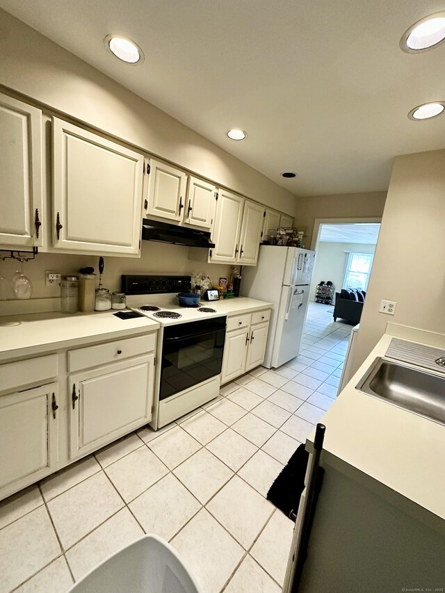 409 Glendale Ave Unit C2, Bridgeport, CT 06606 - kitchen featuring white appliances, under cabinet range hood, light tile patterned floors, light countertops, and white cabinetry