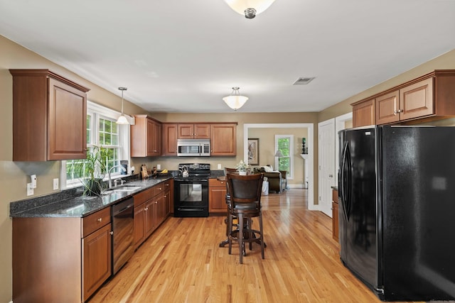 11 Acorn Dr, East Haddam, CT 06423 - kitchen with black appliances, healthy amount of natural light, light wood-style floors, and brown cabinets