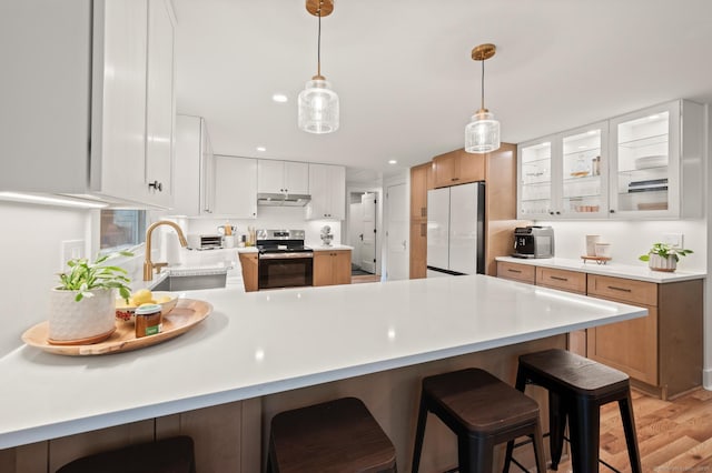 12 Warner Rd, East Haddam, CT 06423 - kitchen with freestanding refrigerator, stainless steel range with electric cooktop, a peninsula, light wood-style flooring, and light countertops