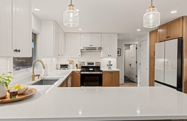 12 Warner Rd, East Haddam, CT 06423 - kitchen with appliances with stainless steel finishes, under cabinet range hood, light countertops, recessed lighting, and decorative light fixtures