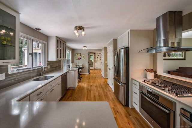 310 Opening Hill Rd, Madison, CT 06443 - kitchen with wall chimney exhaust hood, appliances with stainless steel finishes, light wood-type flooring, backsplash, and glass insert cabinets