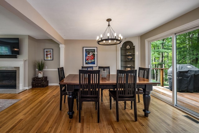 310 Opening Hill Rd, Madison, CT 06443 - dining space with wood finished floors, a chandelier, a premium fireplace, and built in features