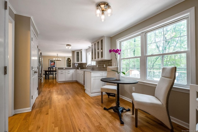 310 Opening Hill Rd, Madison, CT 06443 - kitchen featuring a chandelier, a peninsula, glass insert cabinets, white cabinetry, and light wood-style flooring