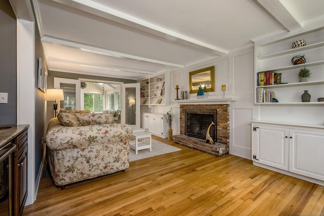 310 Opening Hill Rd, Madison, CT 06443 - living room featuring beamed ceiling, light wood-style flooring, and a fireplace