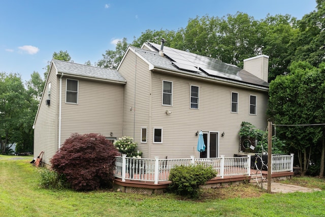 4 Overlook Dr, North Branford, CT 06471 - rear view of property featuring a lawn, roof mounted solar panels, a chimney, a deck, and roof with shingles