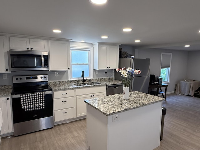 20 Greystone St, Windham, CT 06226 - kitchen with stainless steel appliances, light wood-style floors, white cabinets, light stone counters, and a kitchen island