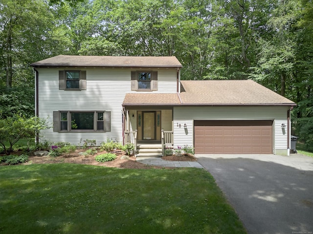 16 Eagle Ridge Dr, Ledyard, CT 06335 - traditional home featuring an attached garage, asphalt driveway, a front lawn, and view of scattered trees