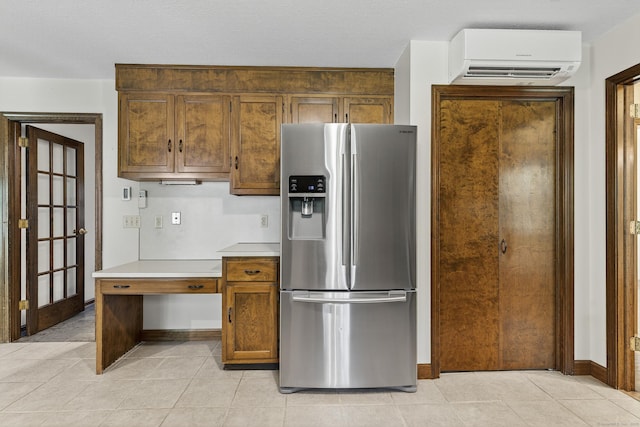 16 Eagle Ridge Dr, Ledyard, CT 06335 - kitchen with stainless steel fridge, an AC wall unit, light countertops, light tile patterned floors, and brown cabinets