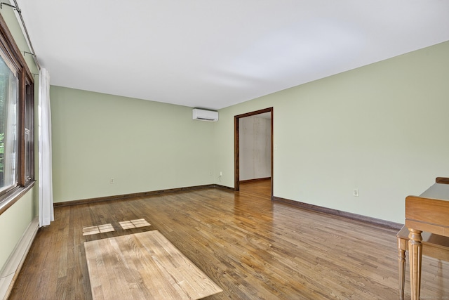 16 Eagle Ridge Dr, Ledyard, CT 06335 - empty room featuring a wall unit AC and wood finished floors