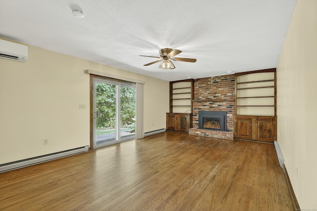 16 Eagle Ridge Dr, Ledyard, CT 06335 - unfurnished living room with a baseboard heating unit, an AC wall unit, ceiling fan, wood finished floors, and a fireplace