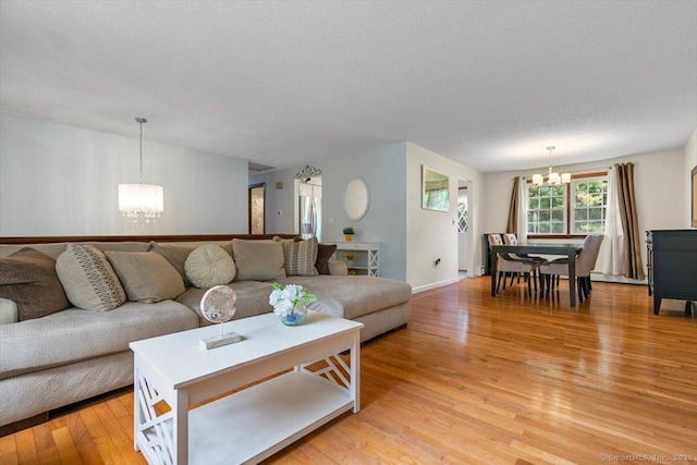 822 New Haven Ave, Milford, CT 06460 - living room with a chandelier, light wood-style flooring, and a textured ceiling