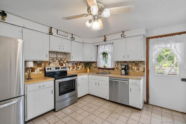 822 New Haven Ave, Milford, CT 06460 - kitchen featuring appliances with stainless steel finishes, healthy amount of natural light, light countertops, a textured ceiling, and backsplash