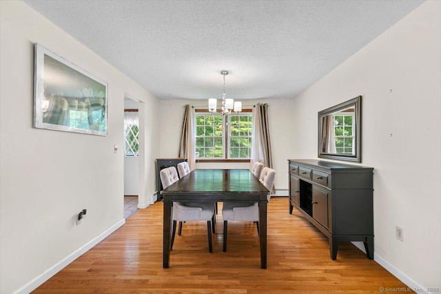 822 New Haven Ave, Milford, CT 06460 - dining space with a chandelier, light wood finished floors, a textured ceiling, and a baseboard radiator