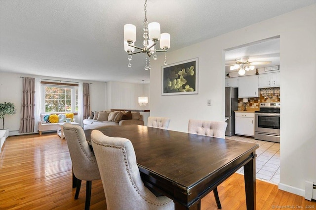 822 New Haven Ave, Milford, CT 06460 - dining space with a chandelier, light wood finished floors, ceiling fan, a baseboard radiator, and a textured ceiling