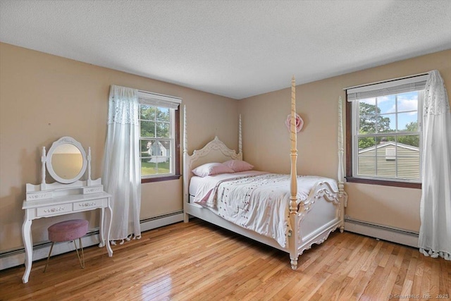 822 New Haven Ave, Milford, CT 06460 - bedroom with baseboard heating, light wood finished floors, and a textured ceiling