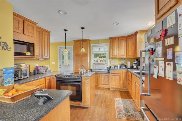 100 Adams Rd, Bloomfield, CT 06002 - kitchen featuring black appliances, light wood-style floors, a peninsula, hanging light fixtures, and dark countertops