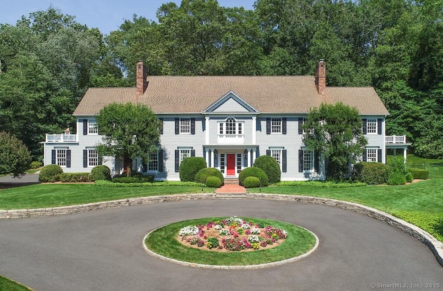 9 Tallwood Rd, Woodbridge, CT 06525 - colonial inspired home with a chimney, curved driveway, and a front lawn