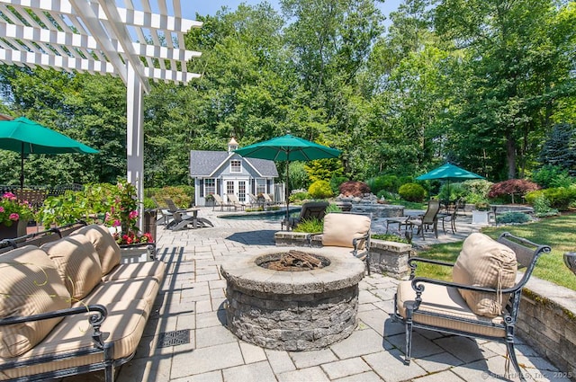 9 Tallwood Rd, Woodbridge, CT 06525 - view of patio / terrace featuring an exterior structure, an outdoor fire pit, an outbuilding, an outdoor pool, and view of scattered trees