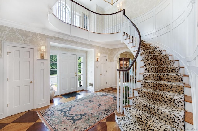 9 Tallwood Rd, Woodbridge, CT 06525 - foyer entrance with crown molding, stairway, arched walkways, wallpapered walls, and a decorative wall
