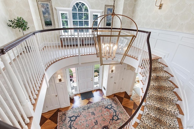 9 Tallwood Rd, Woodbridge, CT 06525 - foyer entrance with wallpapered walls, a decorative wall, arched walkways, stairs, and wainscoting