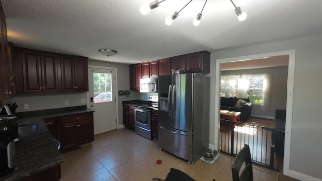 253 E Rd, East Windsor, CT 06016 - kitchen with stainless steel appliances, dark countertops, light tile patterned floors, and a textured ceiling