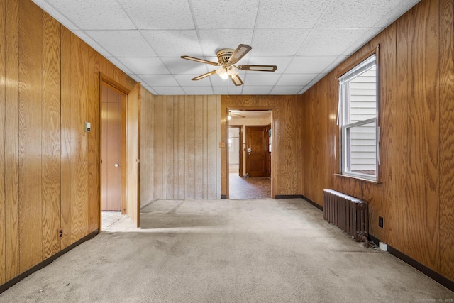 460 Stonybrook Rd, Stratford, CT 06614 - carpeted spare room featuring radiator, ceiling fan, wooden walls, and a paneled ceiling