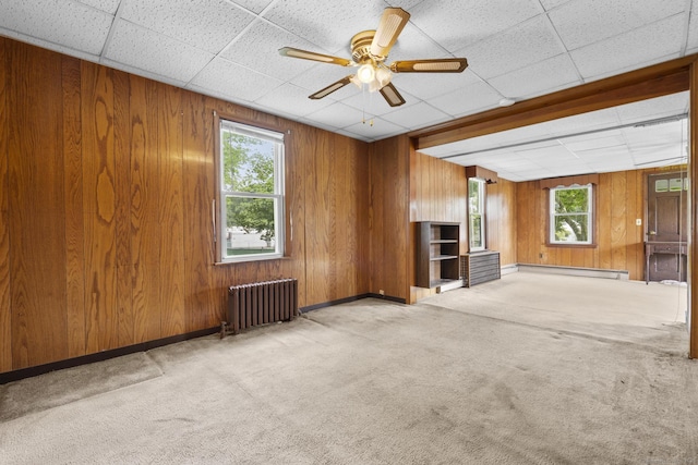 460 Stonybrook Rd, Stratford, CT 06614 - unfurnished living room with radiator, plenty of natural light, carpet flooring, wood walls, and baseboard heating
