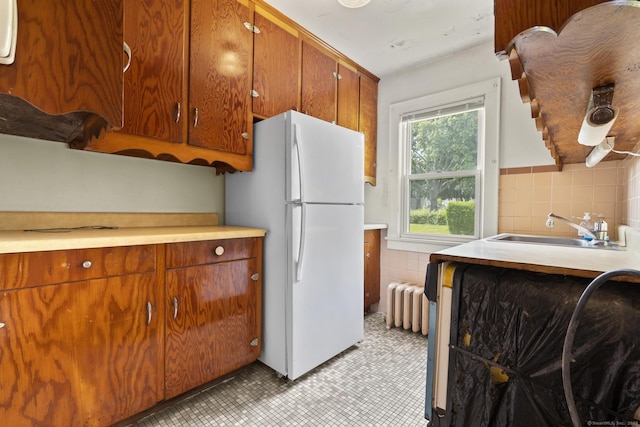 460 Stonybrook Rd, Stratford, CT 06614 - kitchen featuring freestanding refrigerator, light countertops, brown cabinets, radiator, and decorative backsplash