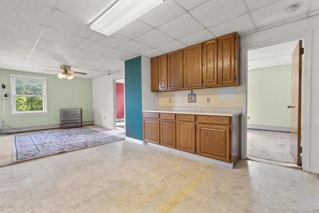 460 Stonybrook Rd, Stratford, CT 06614 - kitchen with a drop ceiling, brown cabinetry, light countertops, ceiling fan, and baseboard heating