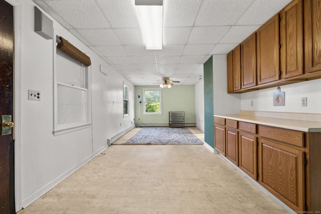 460 Stonybrook Rd, Stratford, CT 06614 - kitchen with a paneled ceiling, brown cabinetry, light countertops, ceiling fan, and baseboard heating