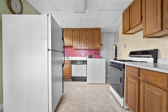 460 Stonybrook Rd, Stratford, CT 06614 - kitchen featuring white appliances, washer / dryer, a paneled ceiling, light countertops, and brown cabinetry