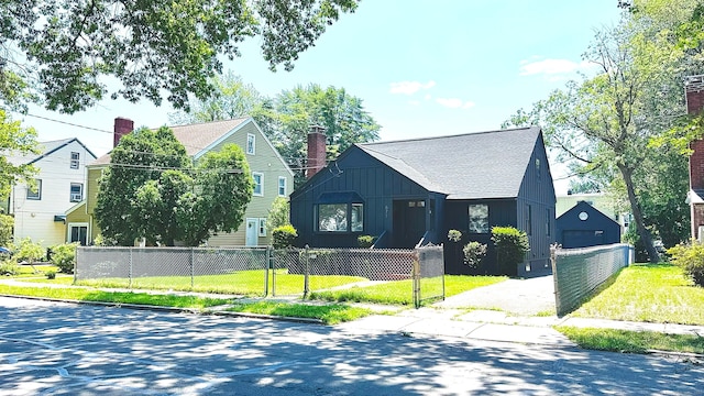 671 Fairview Ave, Bridgeport, CT 06606 - view of front of home with board and batten siding, a fenced front yard, a chimney, and a gate