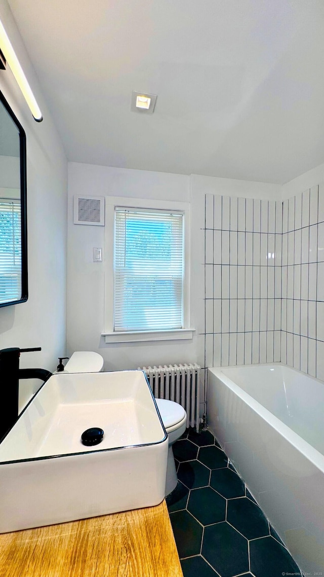 671 Fairview Ave, Bridgeport, CT 06606 - bathroom with radiator heating unit, a tub, tile patterned flooring, and plenty of natural light