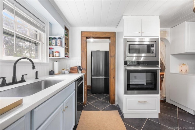 10 Gifford Ln, Norwich, CT 06389 - kitchen with appliances with stainless steel finishes, dark tile patterned floors, white cabinetry, light countertops, and wood ceiling