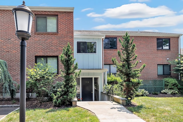 6 Hills Ln Unit 6, Norwalk, CT 06880 - view of front of property with board and batten siding, brick siding, and a front yard