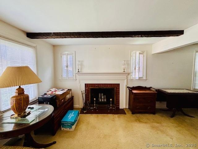 84 Blamey Cir, Stratford, CT 06614 - carpeted living room featuring beam ceiling and a fireplace