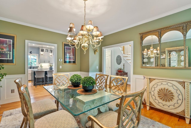 80 Jeremiahs Way, Glastonbury, CT 06073 - dining room with a chandelier, wood finished floors, crown molding, a wainscoted wall, and stairs