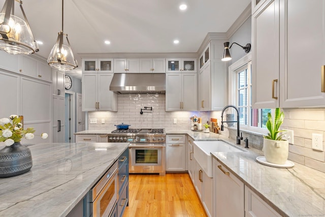 80 Jeremiahs Way, Glastonbury, CT 06073 - kitchen featuring extractor fan, appliances with stainless steel finishes, light stone countertops, decorative light fixtures, and tasteful backsplash