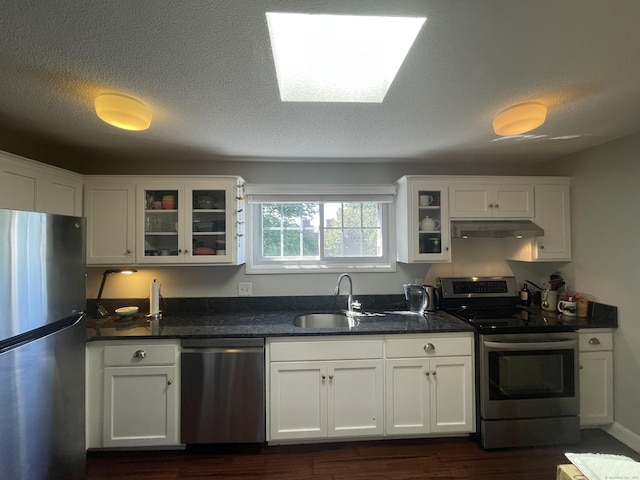 500 Prospect St Apt 4A, New Haven, CT 06511 - kitchen featuring stainless steel appliances, under cabinet range hood, dark wood-type flooring, white cabinetry, and glass insert cabinets