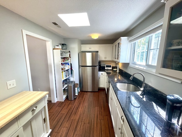 500 Prospect St Apt 4A, New Haven, CT 06511 - kitchen with freestanding refrigerator, glass insert cabinets, white cabinetry, white microwave, and a textured ceiling