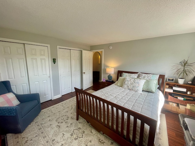 500 Prospect St Apt 4A, New Haven, CT 06511 - bedroom featuring multiple closets, wood finished floors, a textured ceiling, and arched walkways