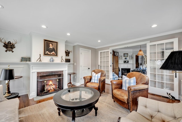 75 Green Hill Rd, Washington, CT 06793 - living area featuring a warm lit fireplace, ornamental molding, french doors, wood finished floors, and recessed lighting