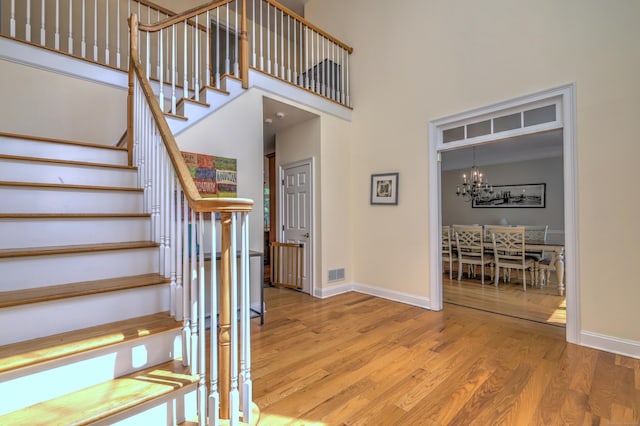 8 Dogwood Ct, Woodbridge, CT 06525 - staircase with wood finished floors, a chandelier, and a high ceiling