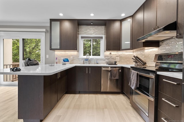 3 Radio Pl Unit 3, Stamford, CT 06906 - kitchen with stainless steel appliances, under cabinet range hood, a peninsula, dark brown cabinetry, and recessed lighting