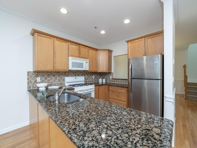 570 Danbury Rd Unit 14, Ridgefield, CT 06877 - kitchen with white appliances, a peninsula, crown molding, dark stone counters, and light wood-style floors