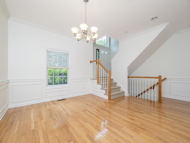 570 Danbury Rd Unit 14, Ridgefield, CT 06877 - empty room featuring a decorative wall, wood-type flooring, a chandelier, ornamental molding, and a wainscoted wall